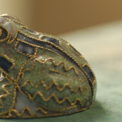 Little frog sculpture facing away macro